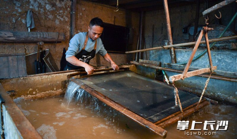 浏阳市张坊镇上洪村道官冲非遗生态村的黄建洪是浏阳手工竹纸制作技艺第五代传承人。